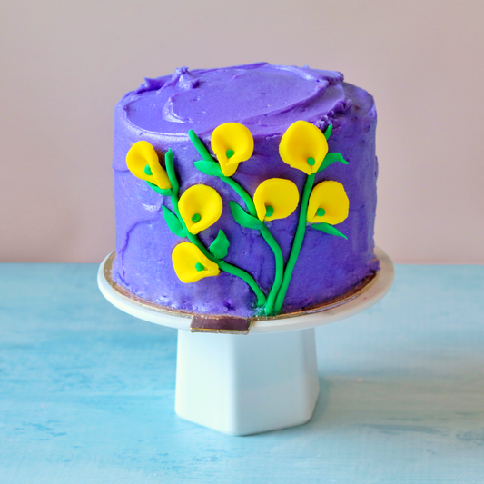 Purple mini cake with fondant yellow lilies.
