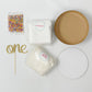 Smash cake kit with cake mix, frosting mix, sprinkles, and one gold glitter cake topper